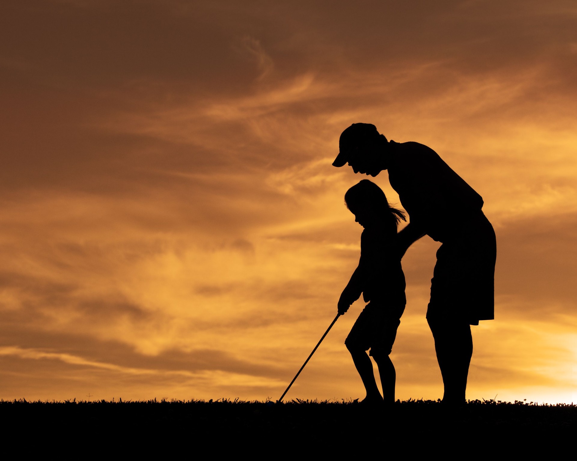 Silhouette of Father Helping Daughter Golf